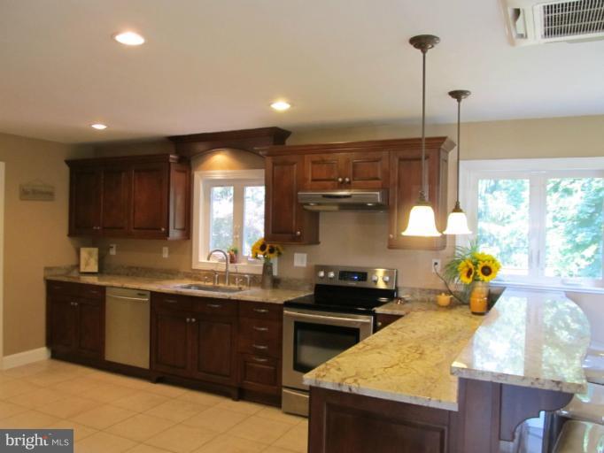 2504 Pleasantville Road Fallston, MD 21047 - Photo 23 of 30 a kitchen with stainless steel appliances granite countertop a sink a stove and a wooden floor
