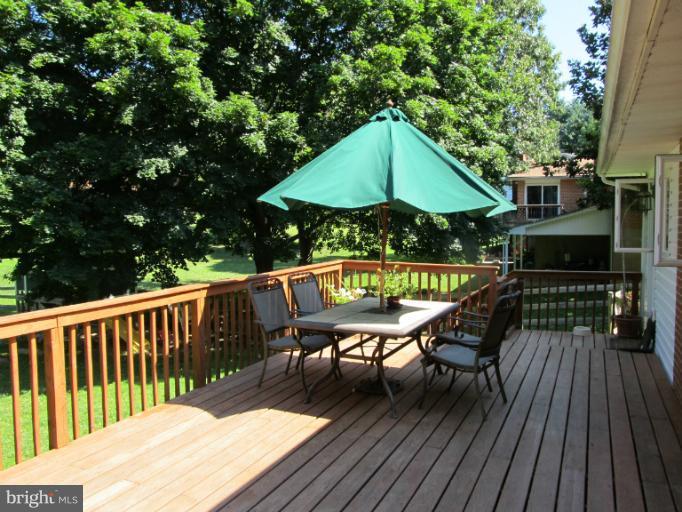 2504 Pleasantville Road Fallston, MD 21047 - Photo 25 of 30 a roof deck with table and chairs under an umbrella with wooden floor
