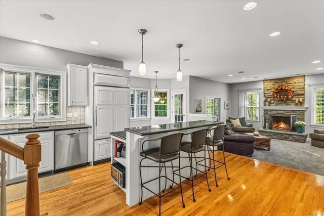 a kitchen with stainless steel appliances granite countertop a stove and a wooden floors