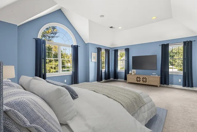 a spacious bedroom with a bed and a flat screen tv