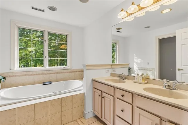 a bathroom with a tub a sink and a window