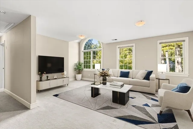 a living room with furniture flat screen tv and a large window