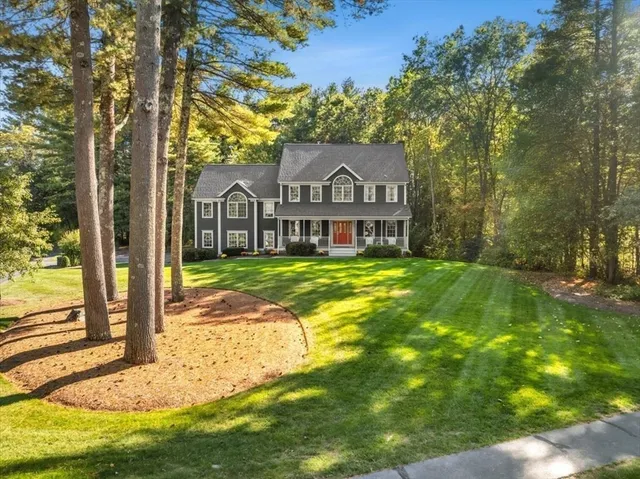 a view of a house with a big yard and large tree