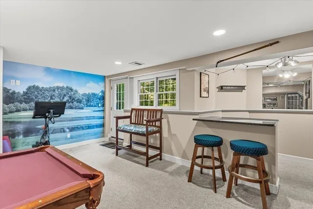 a room with furniture pool table and window