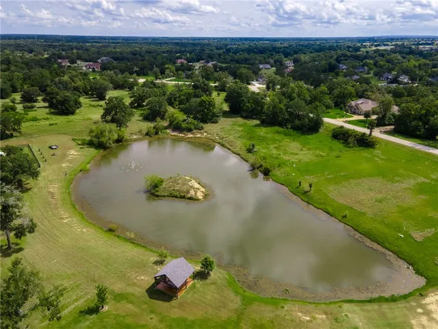 an aerial view of a house with a yard and lake view