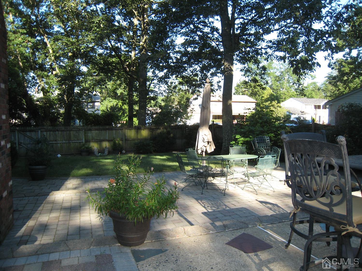 29 Revock Road East Brunswick, NJ 08816 - Photo 4 of 40 a view of a patio with table and chairs potted plants and large tree
