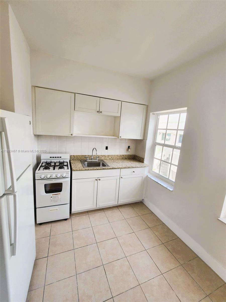 7611 Harding Avenue, Unit 8 Miami Beach, FL 33141 - Photo 5 of 19 a kitchen with a stove a sink and a refrigerator