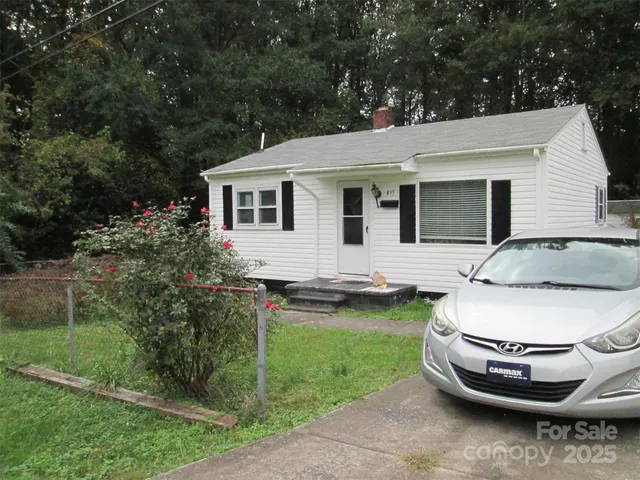 a view of a white house with a sink and garden