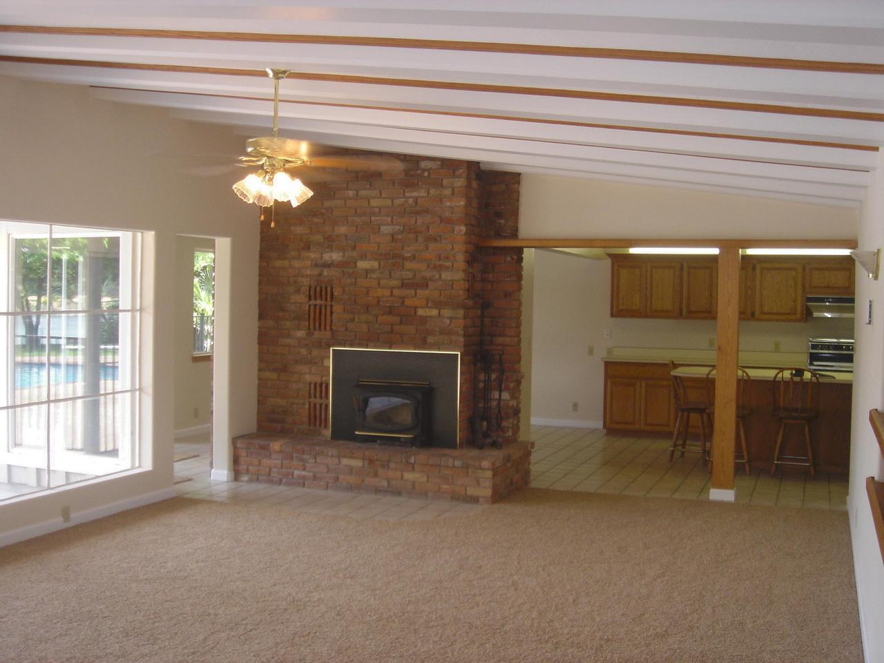 6341 Riverside Drive Redding, CA 96001 - Photo 19 of 20 a view of a livingroom with a fireplace a chandelier and couches