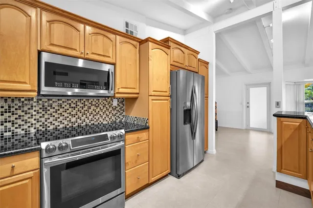 a kitchen with granite countertop cabinets stainless steel appliances and a counter space