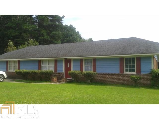 1521 Cardinal Road, Unit 13 Hampton, GA 30228 - Photo 1 of 1 a black and white house in front of a big yard with large trees