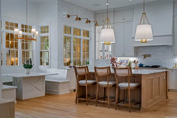 a dining room with wooden floor a chandelier a glass table and chairs