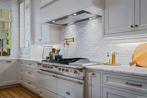 a kitchen with stainless steel appliances granite countertop a sink stove and cabinets