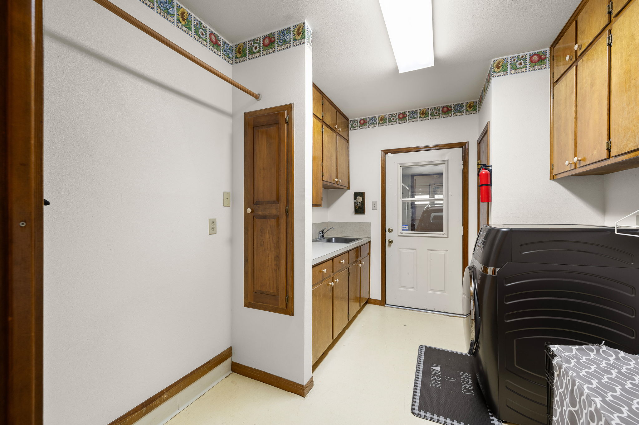136 Valley View Road Georgetown, TX 78633 - Photo 27 of 40 Oversized laundry room with old-school built-in ironing board, room to hang your clothes to dry and an actual sink and countertop along with cabinets for storage.