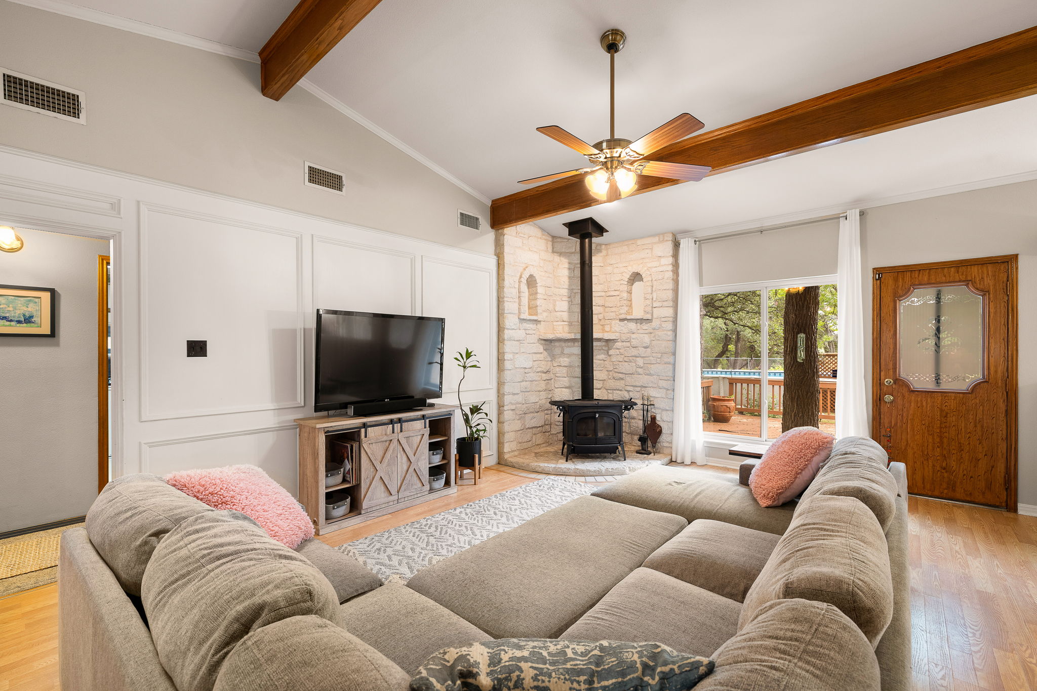 136 Valley View Road Georgetown, TX 78633 - Photo 10 of 40 This oversized living room has more than one option for TV placement. Love the character this space has with wood panels, wooden beams and stone-backed wood stove. The entry to the secondary bedroom wing is there on the right. The laundry room and garage are off of that hallway as well.