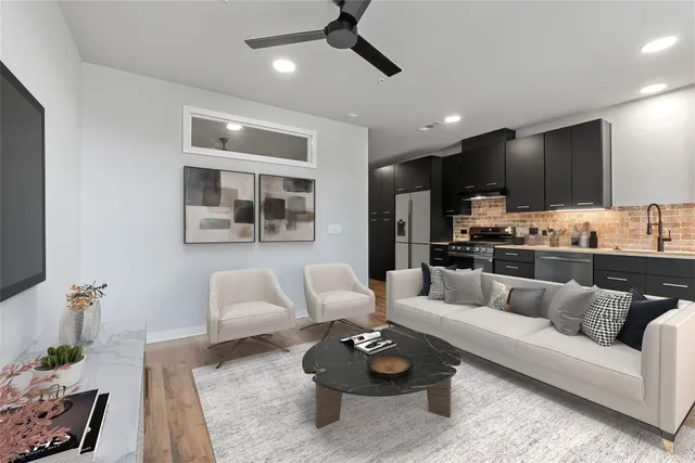 a living room with furniture kitchen view and a window