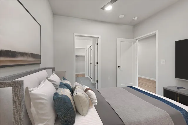 a bedroom with a bed and a flat tv screen on a dresser