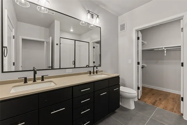 a bathroom with a double vanity sink and mirror with shower