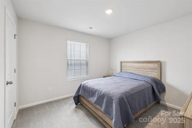 a bed sitting in a bedroom next to a window