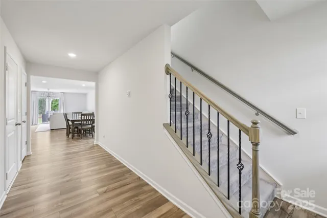 a view of a hallway with wooden floor and stairs