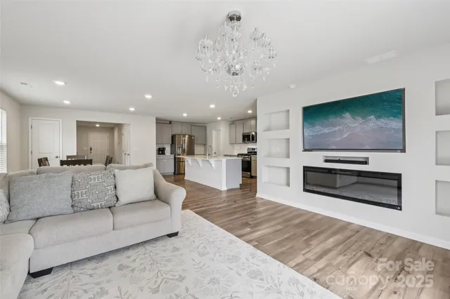 a living room with furniture a flat screen tv and kitchen view