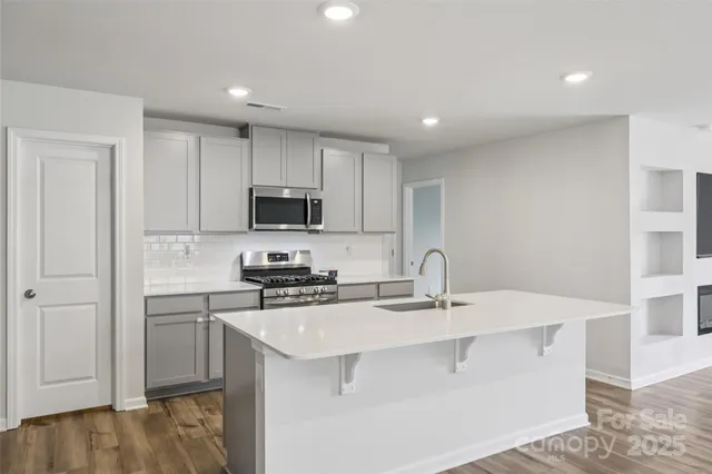 a kitchen with stainless steel appliances a sink stove and cabinets