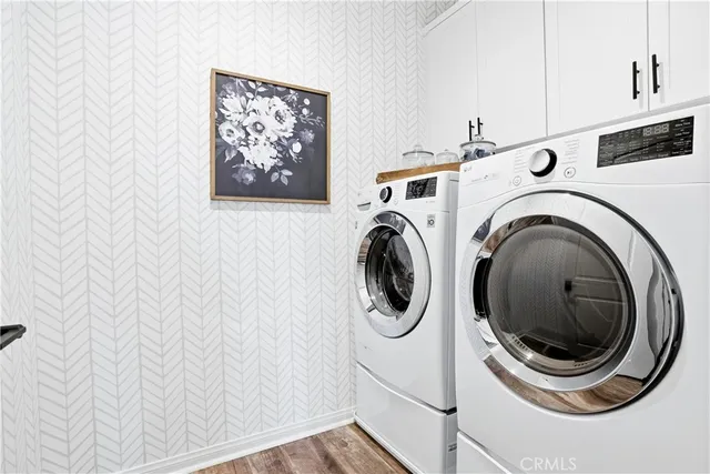 a swimming pool with lawn chairs under an umbrella and palm trees