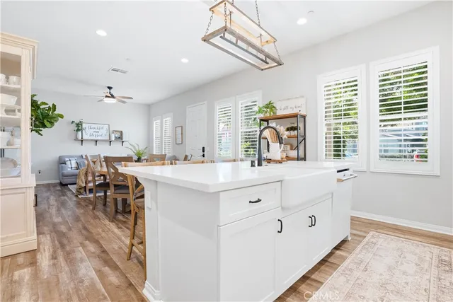 a dining room with furniture a chandelier and wooden floor