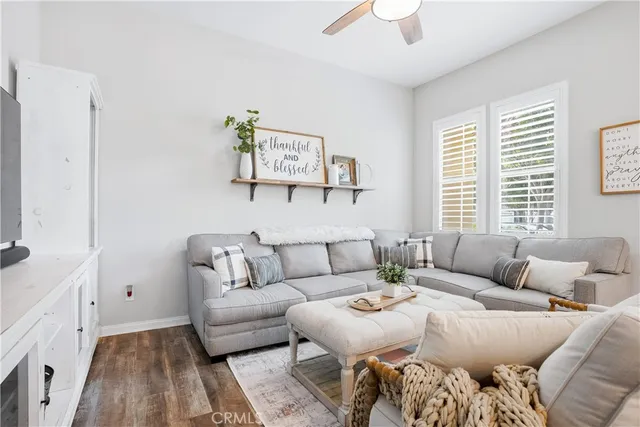 a living room with furniture a flat screen tv and a chandelier