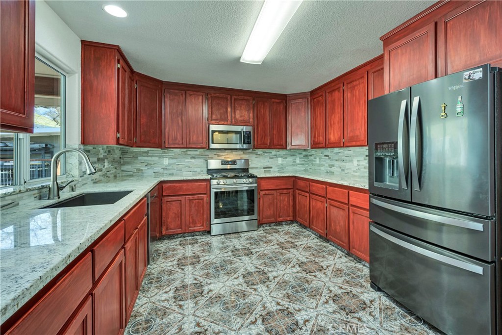 18230 Hidden Valley Road Hidden Valley Lake, CA 95467 - Photo 9 of 22 a kitchen with stainless steel appliances granite countertop a refrigerator sink and cabinets