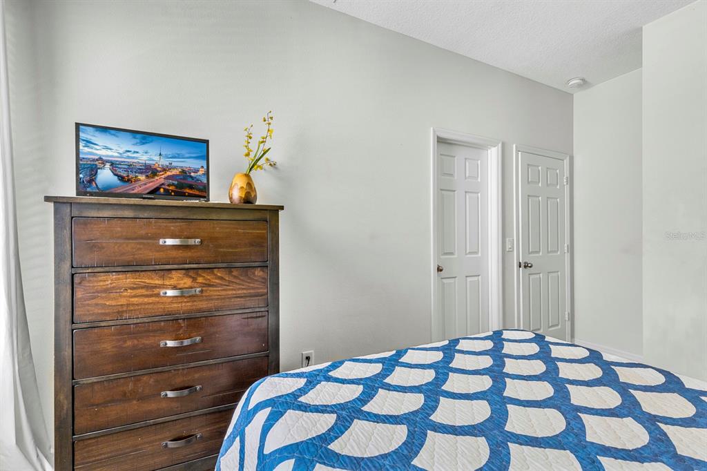 946 Suffolk Place Davenport, FL 33896 - Photo 14 of 41 a bedroom with a bed and a mirror on the dresser