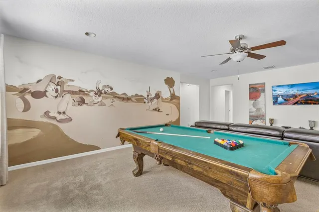 a room with pool table and windows