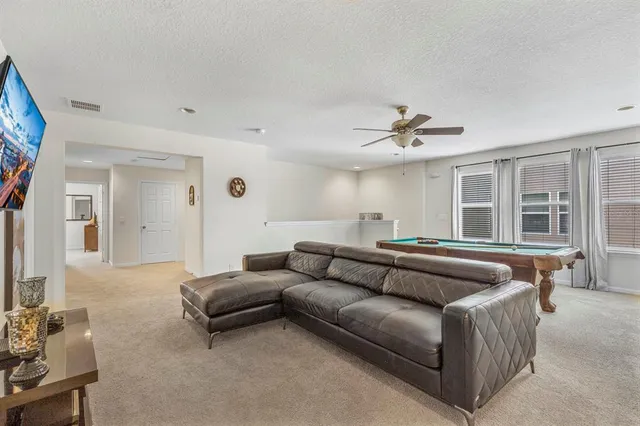 a living room with furniture and a ceiling fan