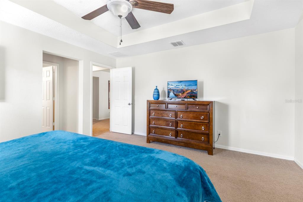 946 Suffolk Place Davenport, FL 33896 - Photo 20 of 41 a bedroom with a bed and a dresser