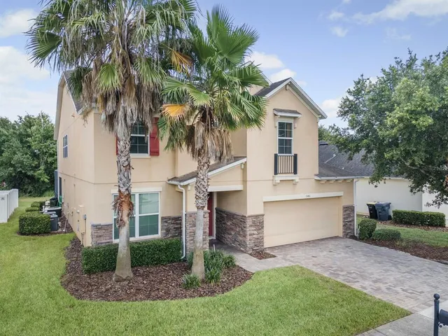 a view of house with a yard and potted plants