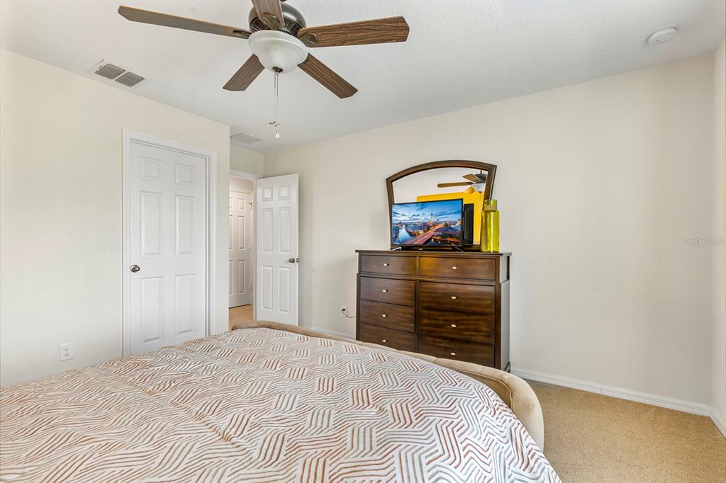 946 Suffolk Place Davenport, FL 33896 - Photo 23 of 41 a bedroom with a bed and a chandelier