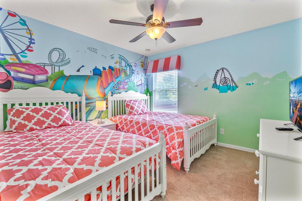 946 Suffolk Place Davenport, FL 33896 - Photo 25 of 41 a bedroom with two beds and a chandelier