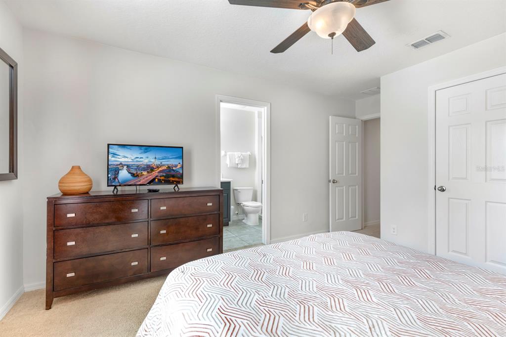 946 Suffolk Place Davenport, FL 33896 - Photo 32 of 41 a bedroom with a bed and a dresser