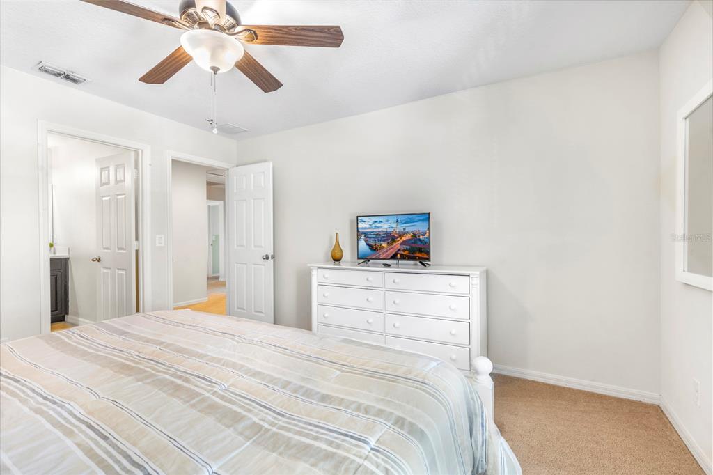 946 Suffolk Place Davenport, FL 33896 - Photo 35 of 41 a bedroom with a bed and a chandelier