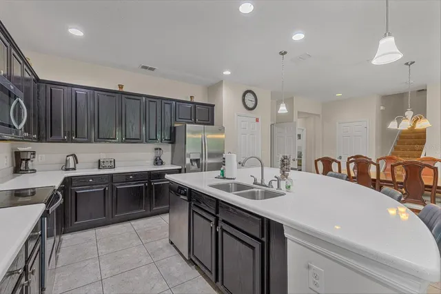 a kitchen with kitchen island granite countertop a sink counter top space appliances and cabinets