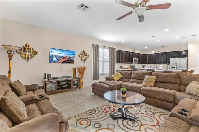 a living room with furniture and a view of kitchen
