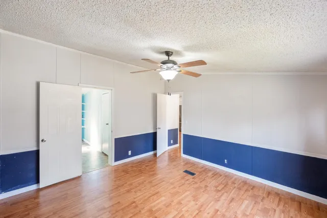 a view of a livingroom with a ceiling fan and wooden floor