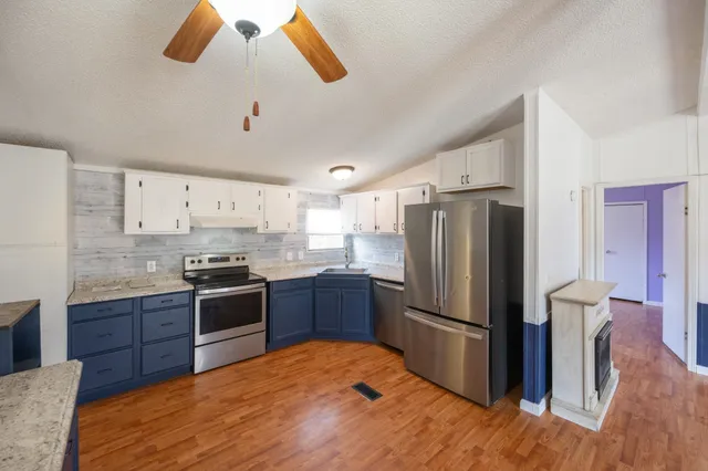 a kitchen with stainless steel appliances granite countertop a refrigerator a stove a sink and a refrigerator