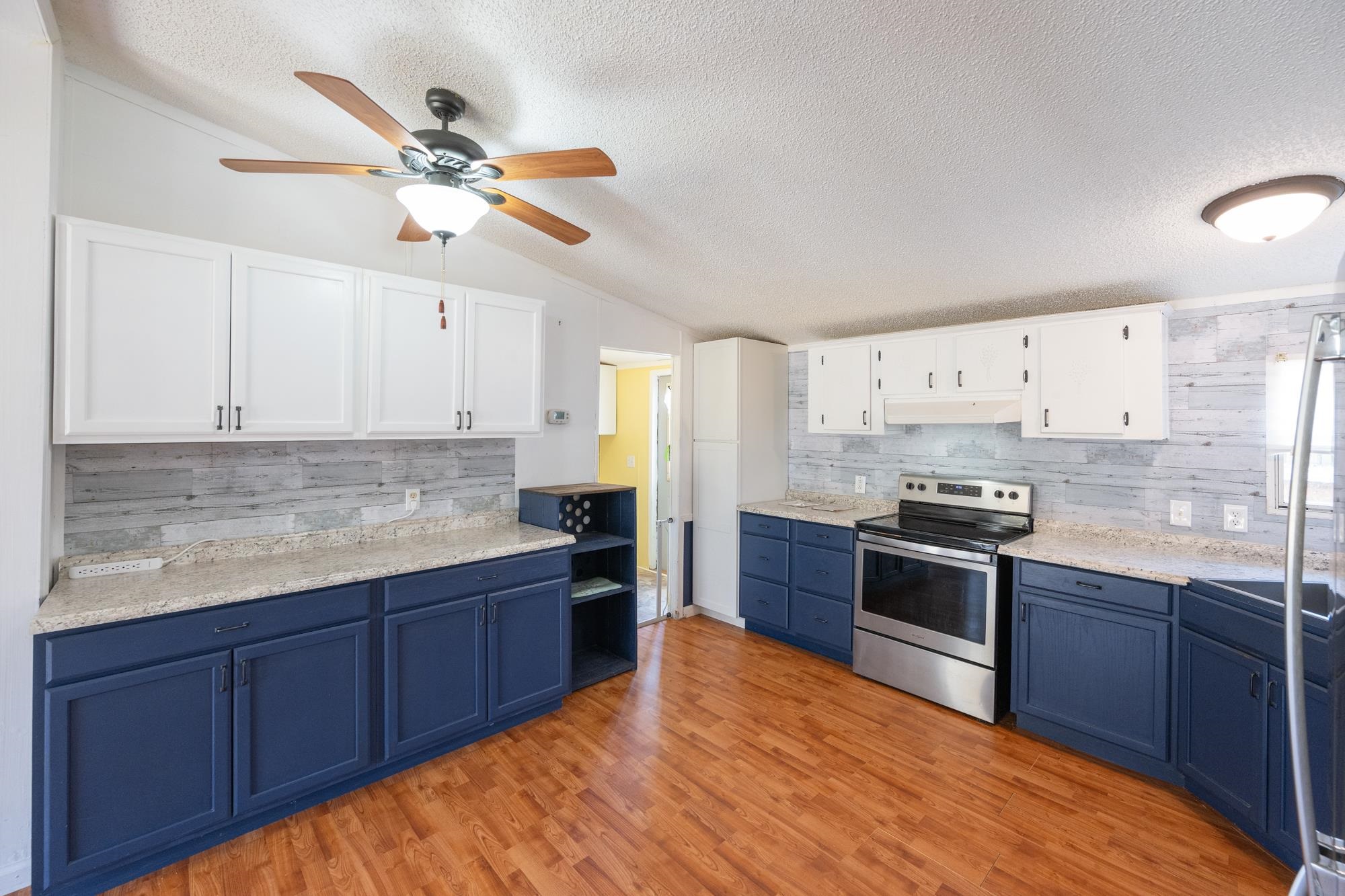 875 Lindsey Road Parsons, TN 38363 - Photo 4 of 38 a kitchen with stainless steel appliances granite countertop a sink and stove top oven