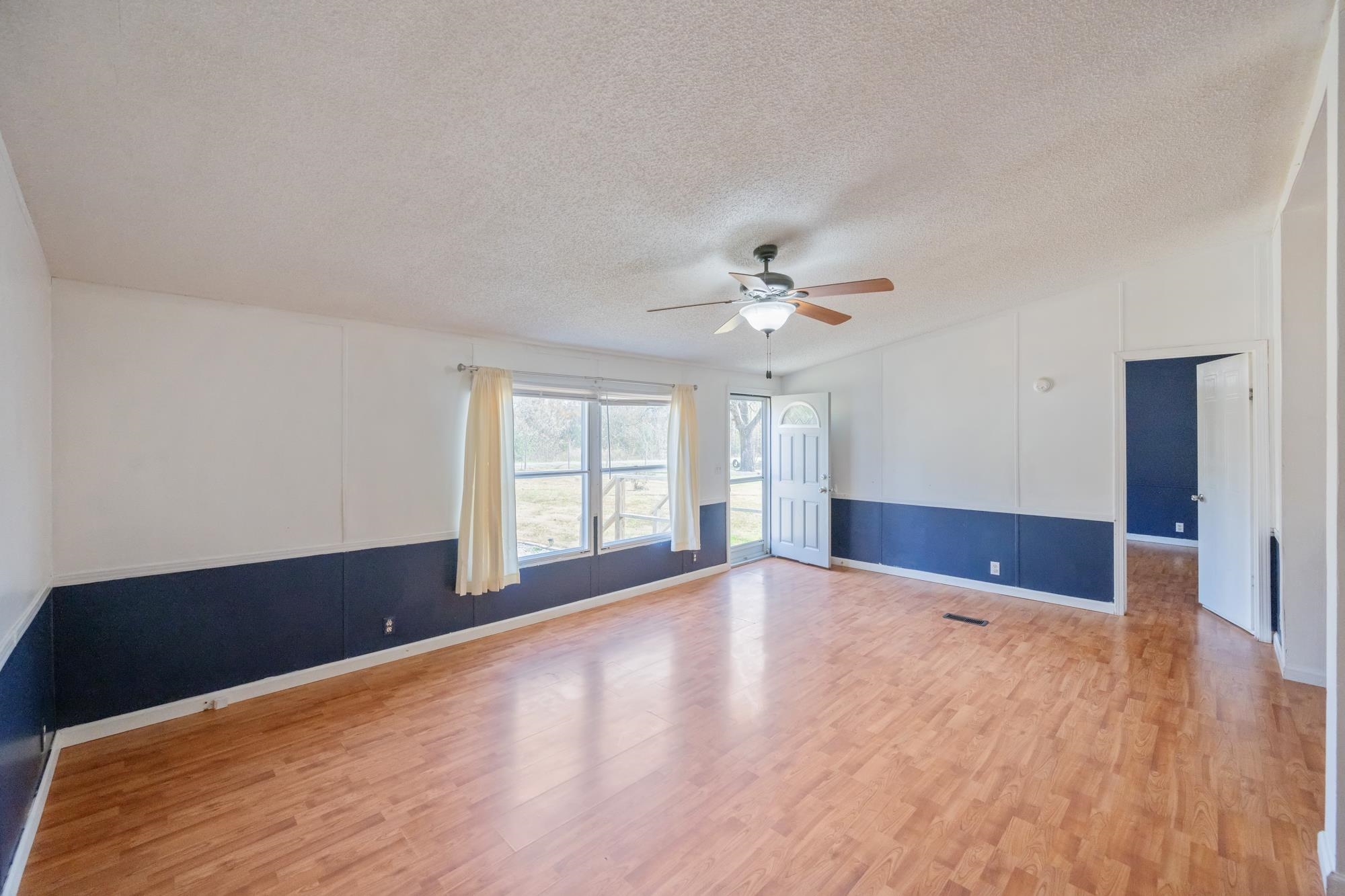 875 Lindsey Road Parsons, TN 38363 - Photo 9 of 38 a view of an empty room with window and wooden floor