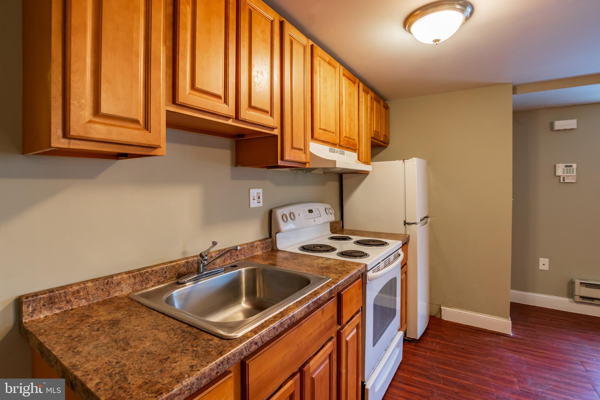 a kitchen with stainless steel appliances granite countertop a sink a stove cabinets and wooden floor