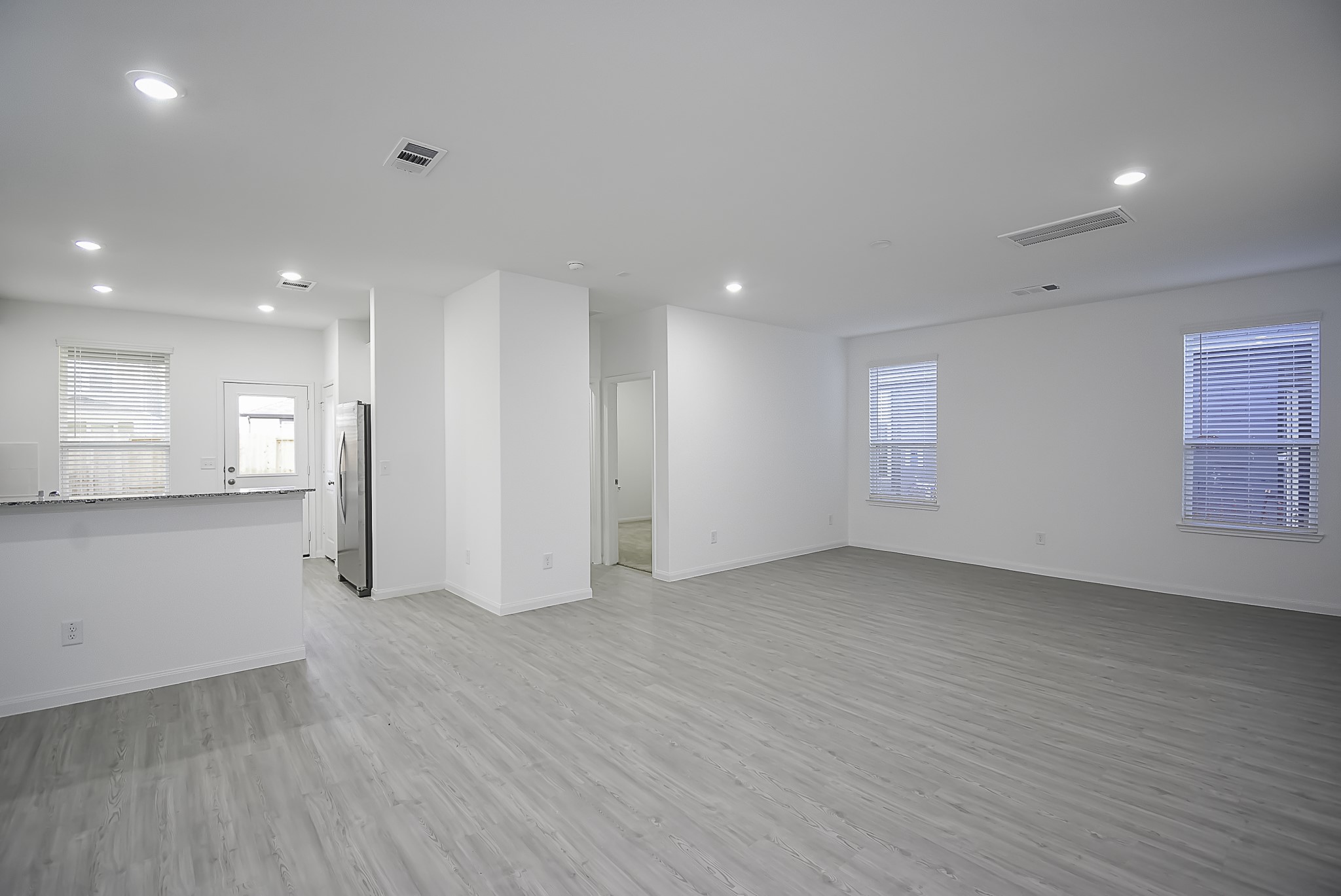 23407 Honey Spade Road Hockley, TX 77447 - Photo 7 of 34 an empty room with wooden floor and windows