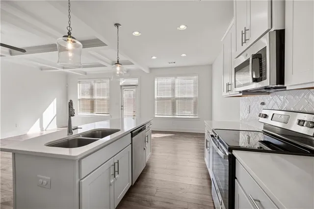 a kitchen with stainless steel appliances granite countertop a sink and a stove