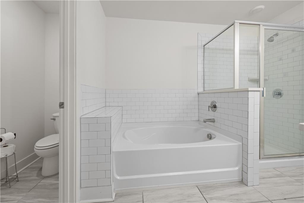 7690 Baron Road Fairburn, GA 30213 - Photo 24 of 29 a bathroom with a bathtub and a toilet