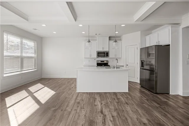 a kitchen with stainless steel appliances a refrigerator and a stove top oven